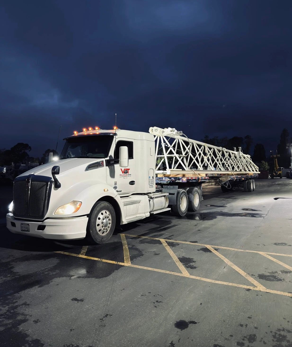 Velazquez Bros truck loaded with a crane truss at blue hour